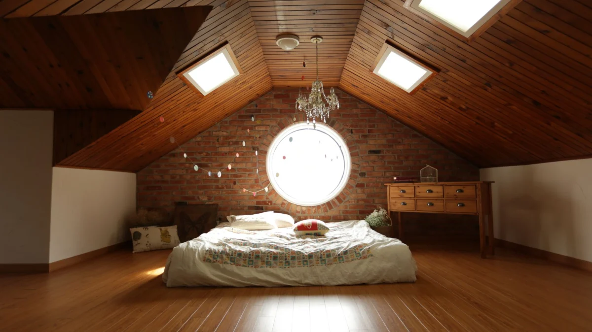 Chambre aménagée sous rampants avec charpente apparente