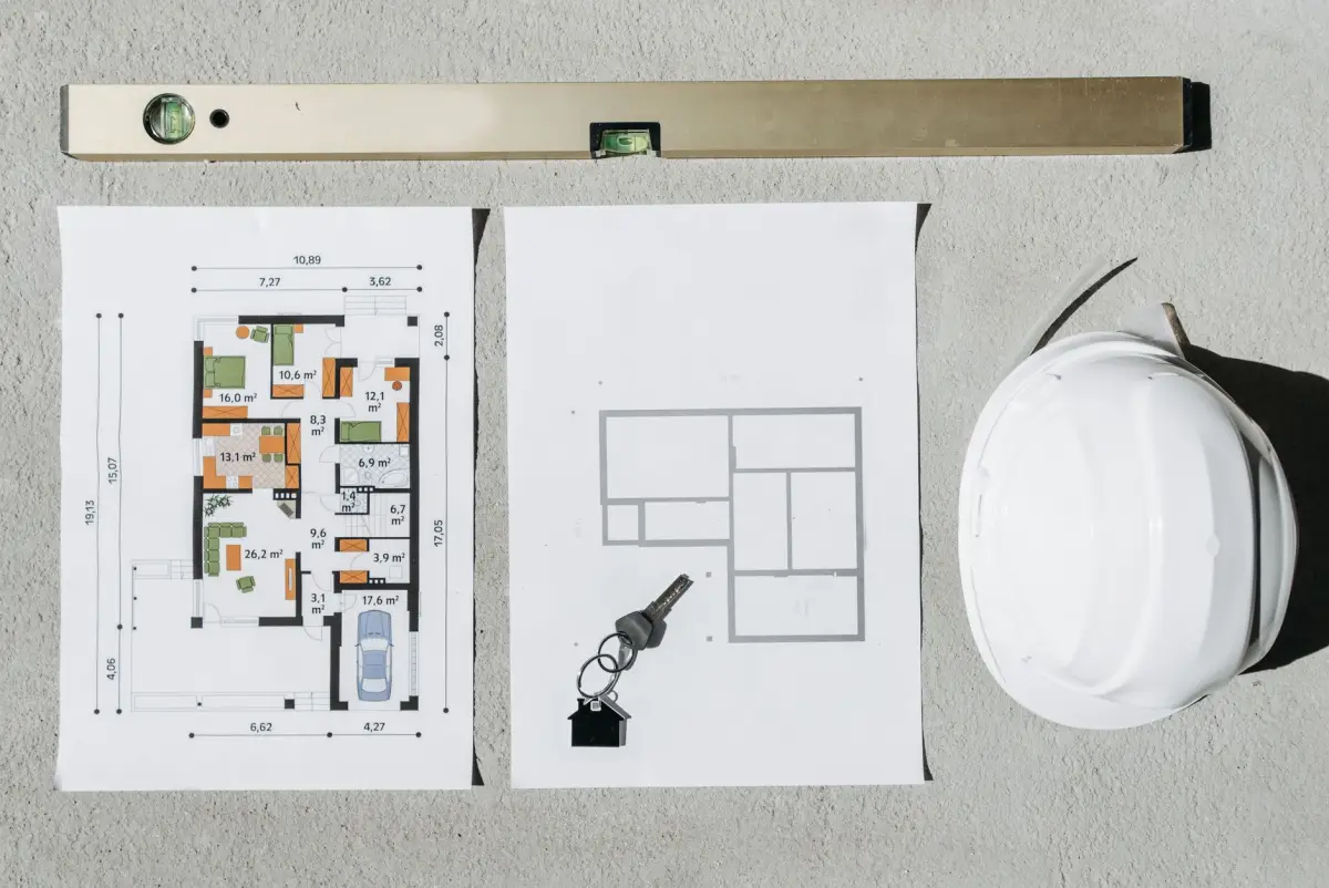 Plans et outil de mesure posés sur une table de chantier